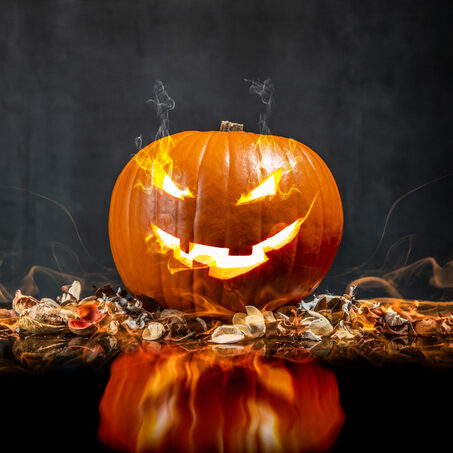 Composition of pumpkin on black background with glowing smoke. Vertical orientation