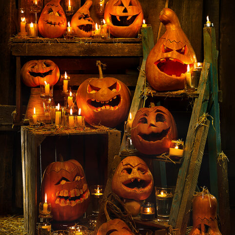 Scary Jack O' Lantern Halloween pumpkins on a wooden background